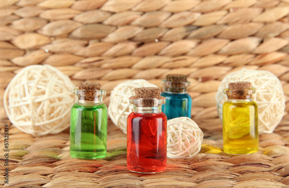 Bottles with colored liquids on wicker wooden background Bottles with colored liquids on wicker wooden background