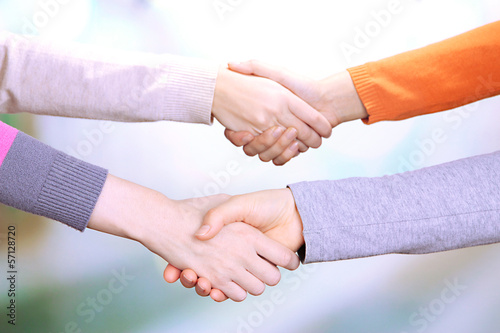 Handshakes on bright background