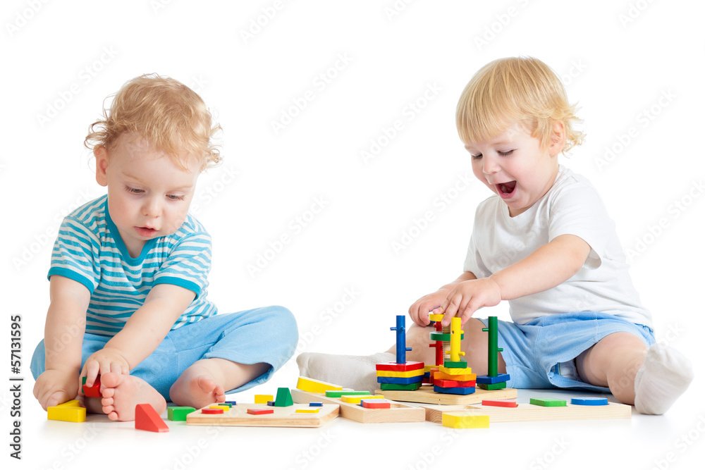 Two kids playing wooden toys together sitting Two kids playing wooden toys together sitting