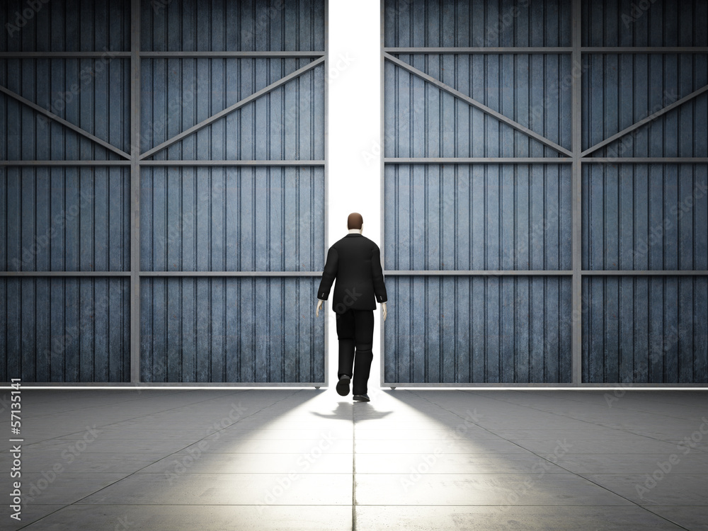 Fototapeta premium Man walks to large hangar doors