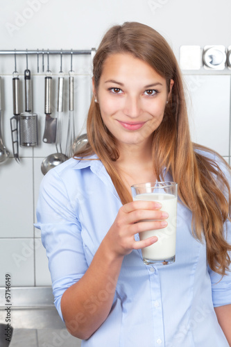 Junge Frau in der Küche trinkt Milch