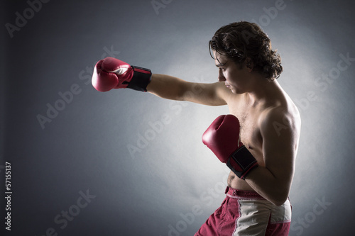 Young Boxer fighter over black background