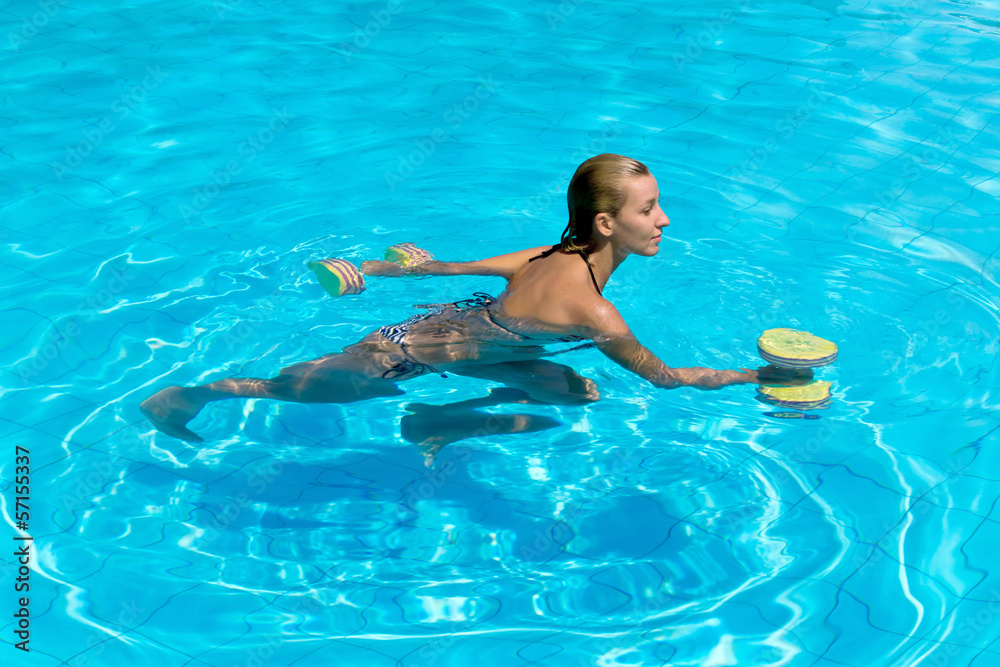 Aqua aerobic, woman in water with dumbbells