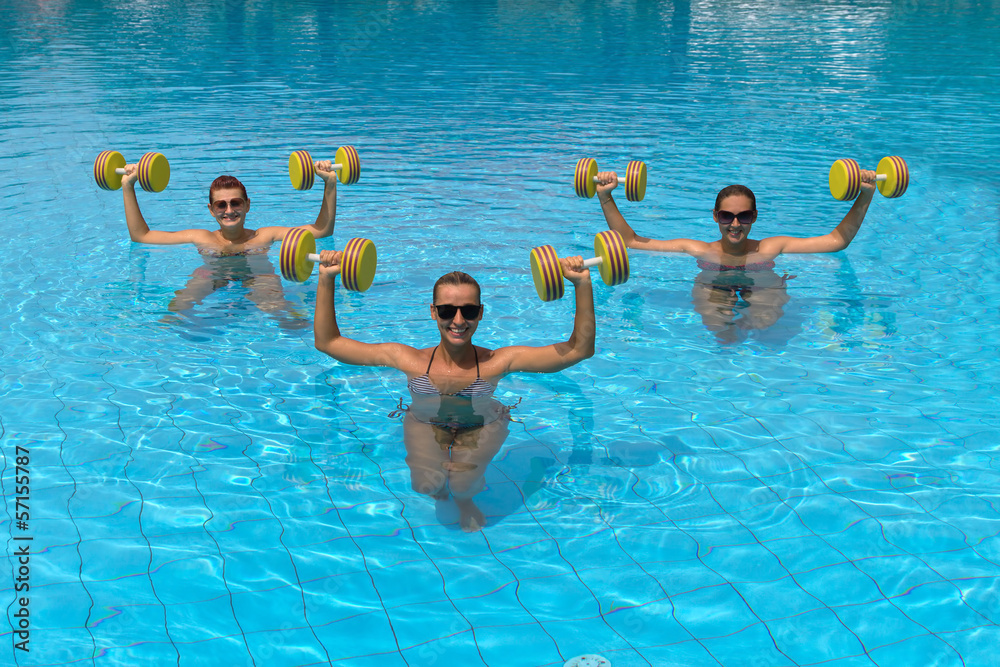 Happy active fitness people doing exercise with aqua dumbbell