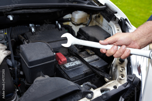 Hands of auto mechanic with wrench.