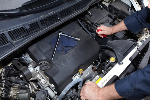 Hands of auto mechanic with wrench.