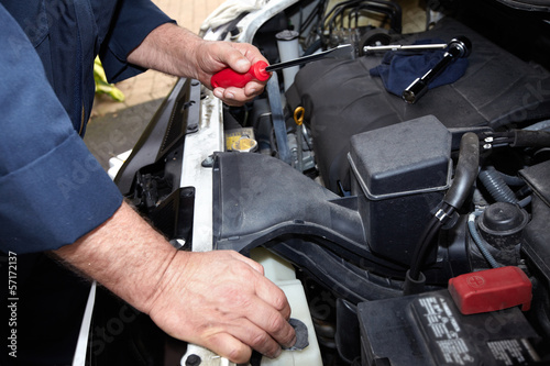 Hands of auto mechanic with wrench.