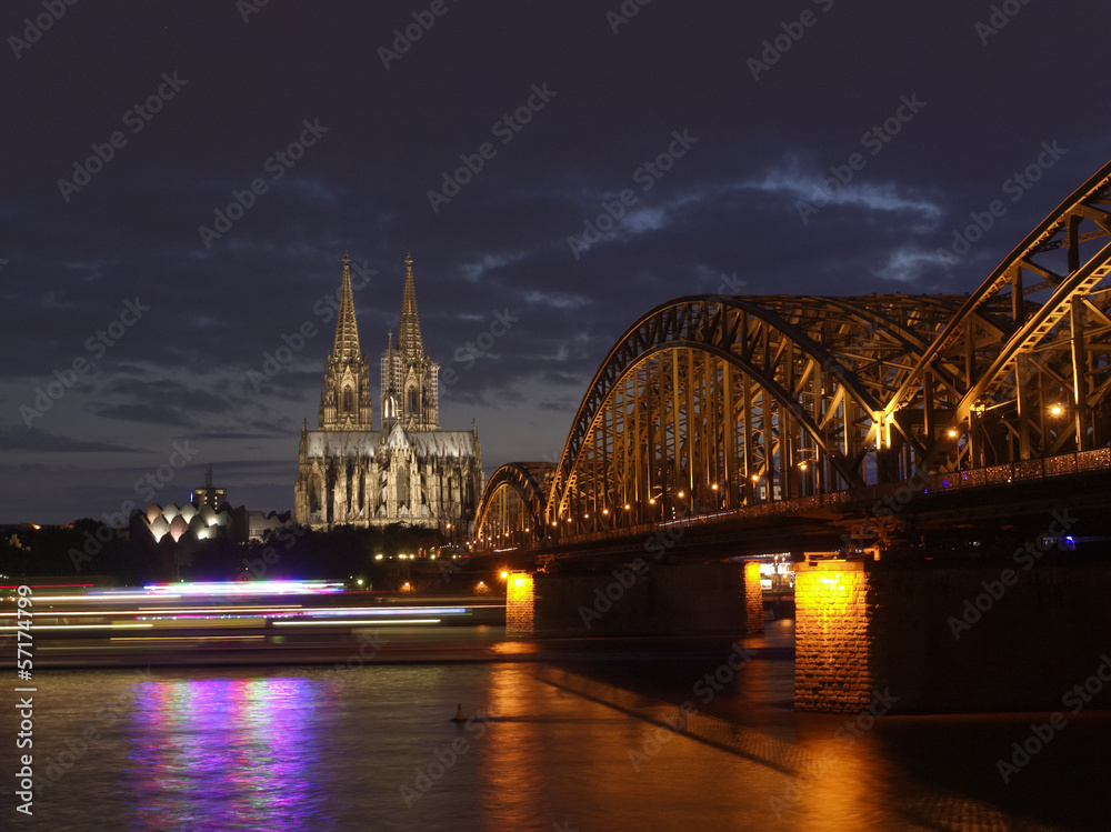 Fototapeta premium 夜のケルン大聖堂とライン川を航行する観光船