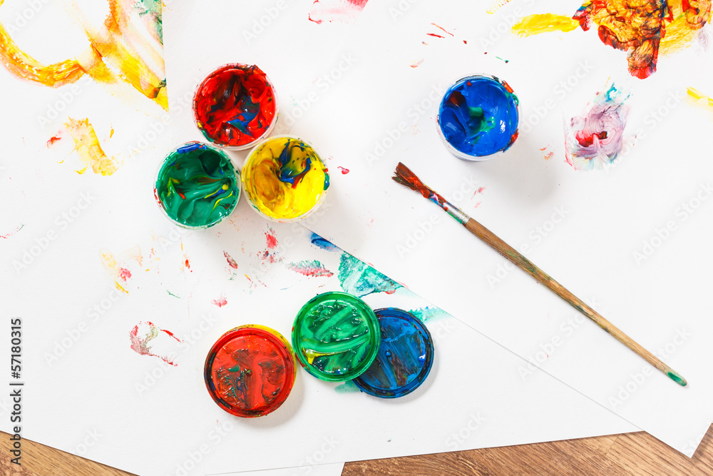 Opened paints with paintbrush on messy paper. Opened paints with paintbrush on messy paper.