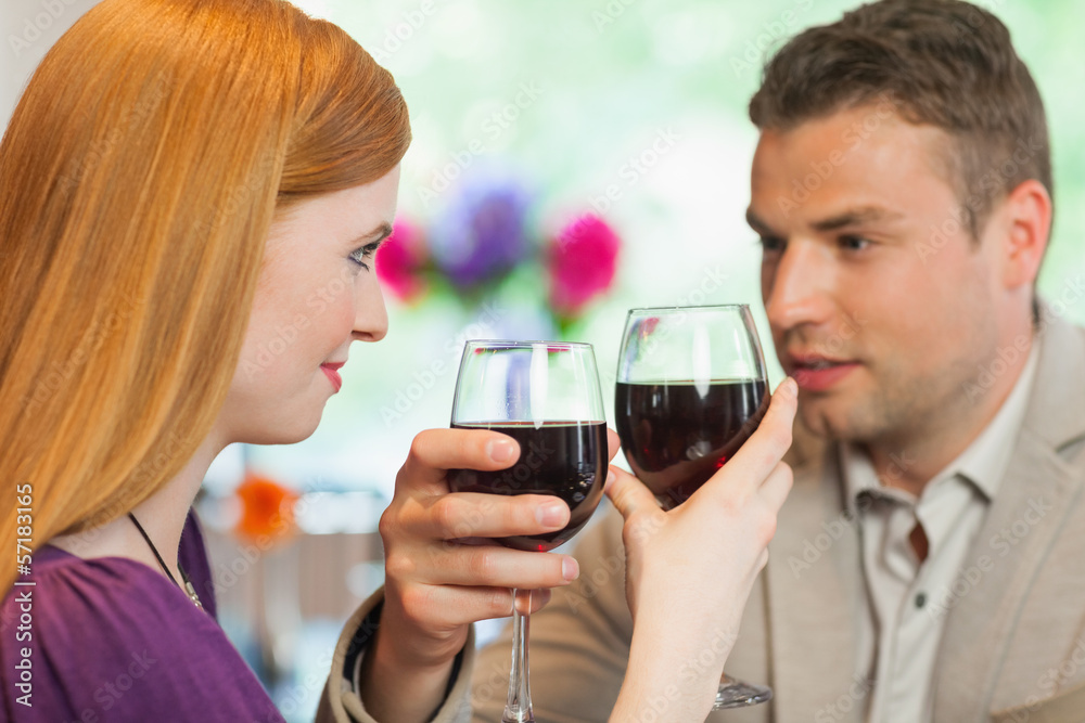 Handsome man having glass of wine with his pretty girlfriend Handsome man having glass of wine with his pretty girlfriend