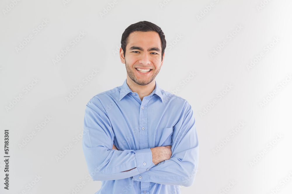 Smiling man standing with arms crossed and looking at camera Smiling man standing with arms crossed and looking at camera