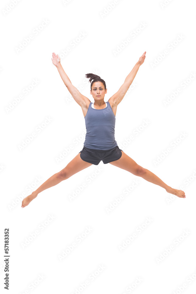 Pretty sporty brunette jumping in the air