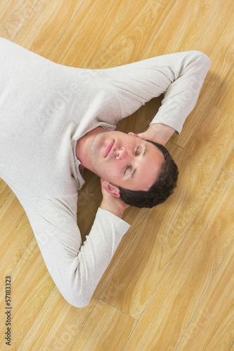Casual peaceful man lying on floor with closed eyes