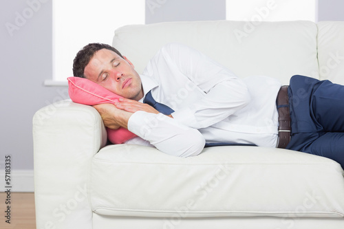 Exhausted handsome businessman lying on couch