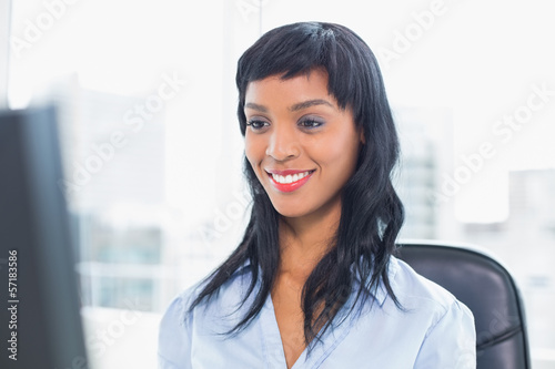 Smiling businesswoman looking at her computer