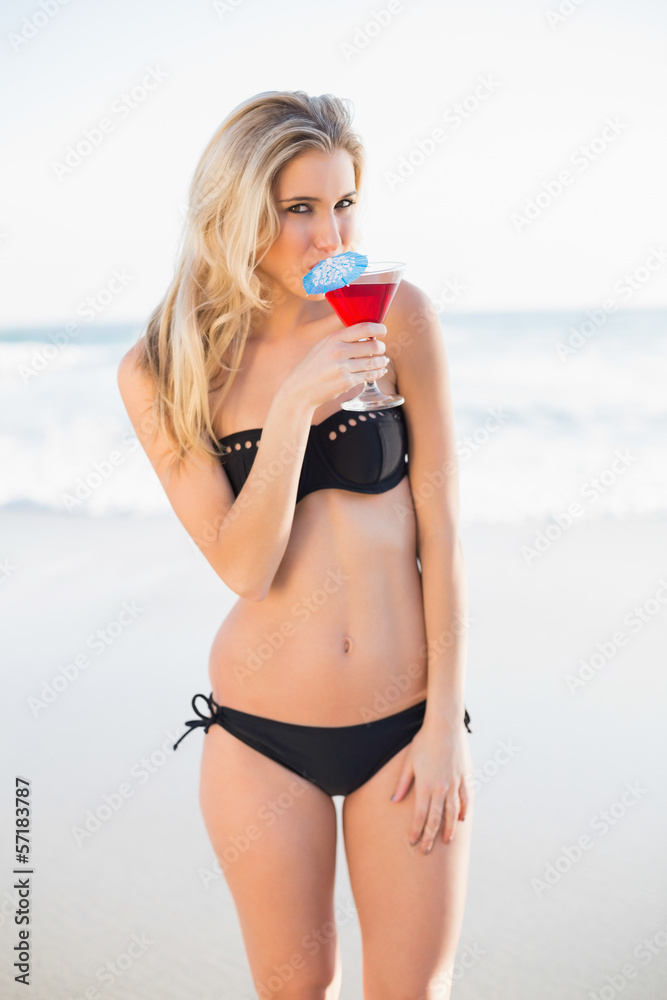 Gorgeous blonde in elegant bikini drinking cocktail