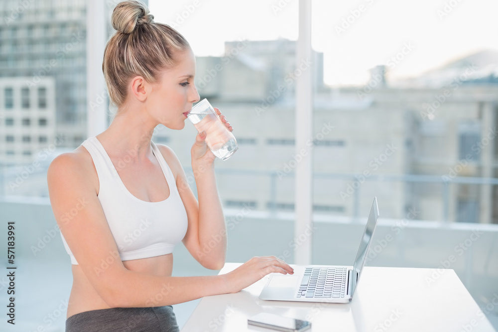 Gorgeous athletic blonde drinking water