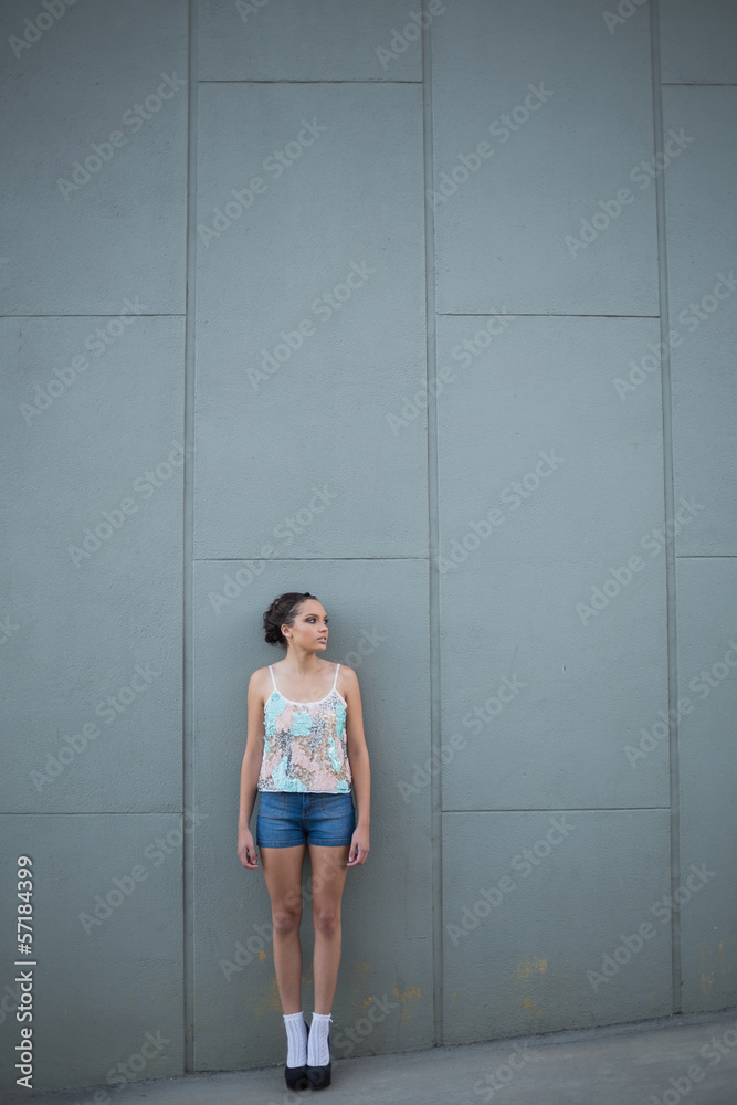 Pretty woman with high heels standing in front of a grey wall Pretty woman with high heels standing in front of a grey wall