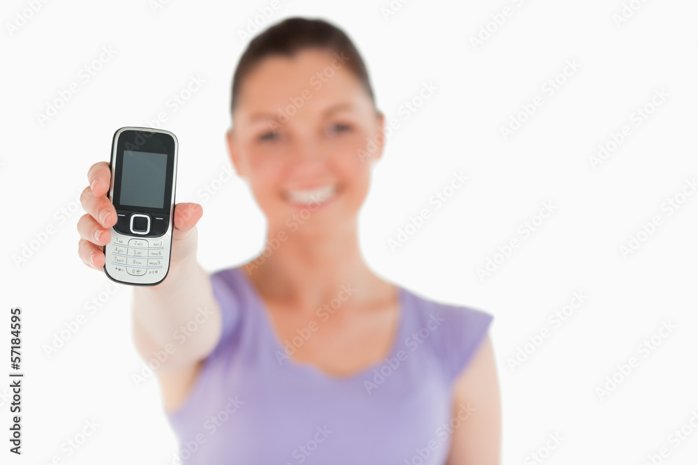 Attractive woman holding and showing her phone while standing Attractive woman holding and showing her phone while standing