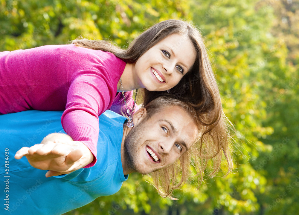 happy young couple piggybacking, arms outstretched. happy young couple piggybacking, arms outstretched.