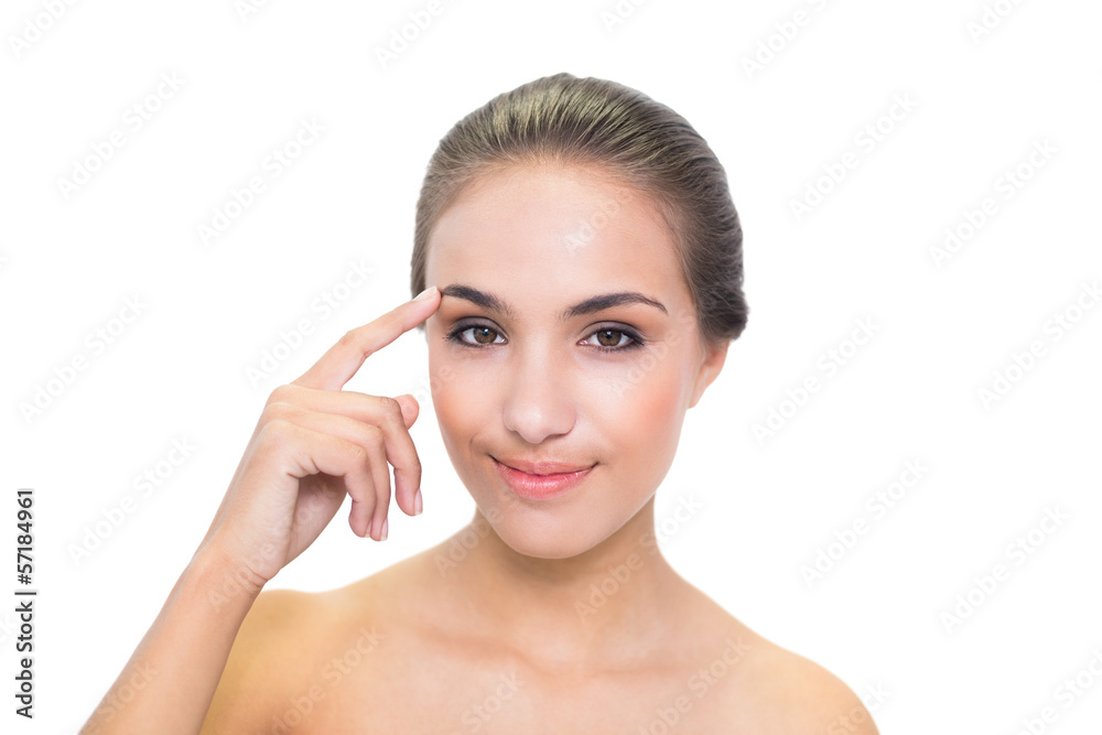 Smiling brunette woman touching her eyebrow Smiling brunette woman touching her eyebrow