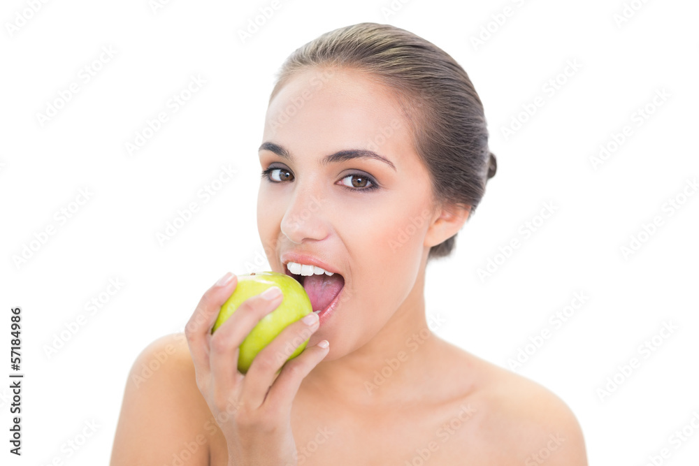 Content young brunette woman biting in a green apple Content young brunette woman biting in a green apple