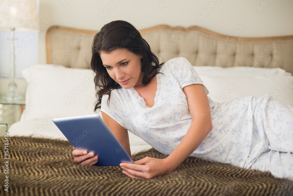 Concentrated pretty brown haired woman using a tablet pc Concentrated pretty brown haired woman using a tablet pc