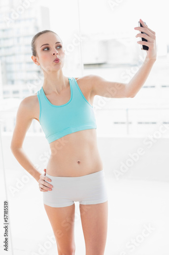 Sporty posing woman holding smartphone