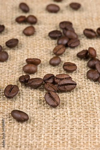 Coffee beans on burlap background close up