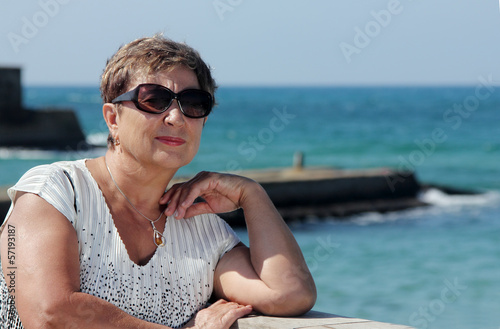 Happy mature woman walking near the sea