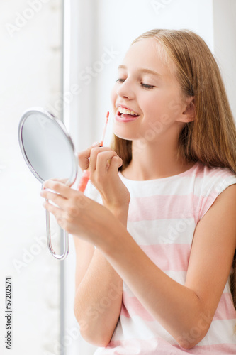 teenage girl with lip gloss and mirror