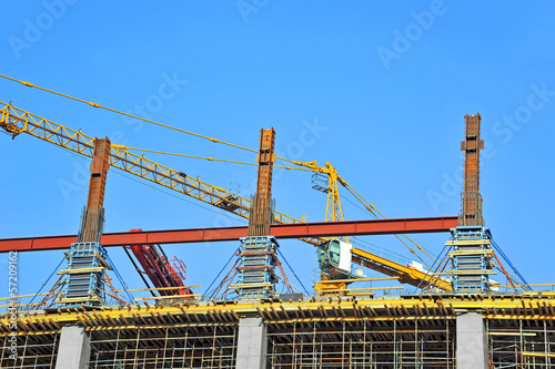 Crane and building construction site against blue sky