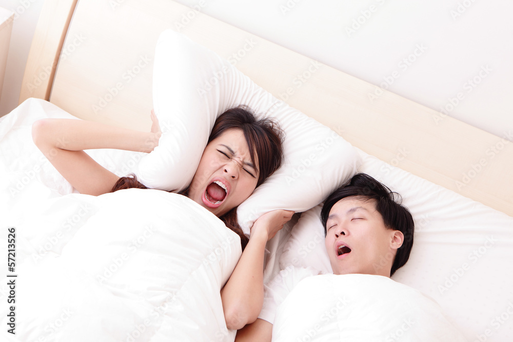 Young woman disturbed by the snores of her husband Young woman disturbed by the snores of her husband