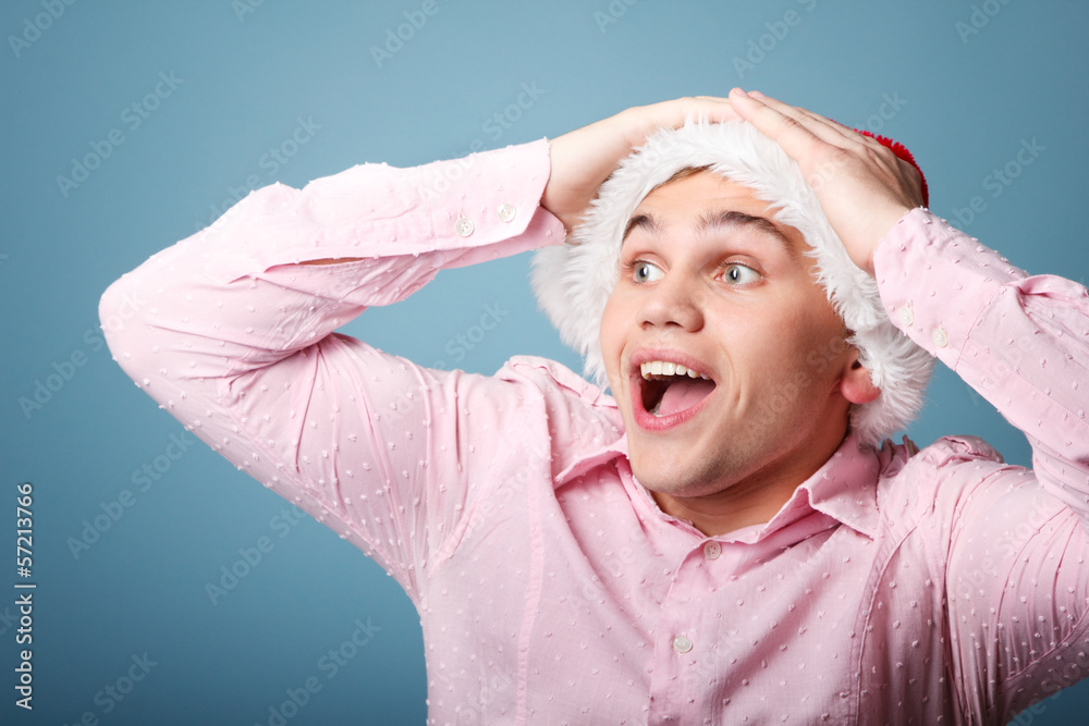surprise young cheerful christmas man with santa's hat over blue surprise young cheerful christmas man with santa's hat over blue