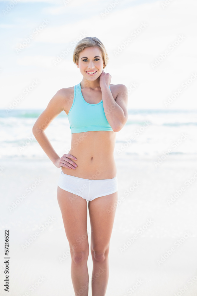 Smiling blonde model in sportswear posing looking at camera