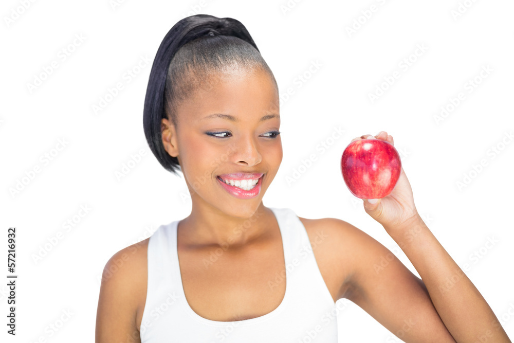 Fit woman wearing sportswear looking at red apple Fit woman wearing sportswear looking at red apple