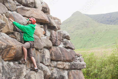 Focused man climbing a large rock face © WavebreakMediaMicro