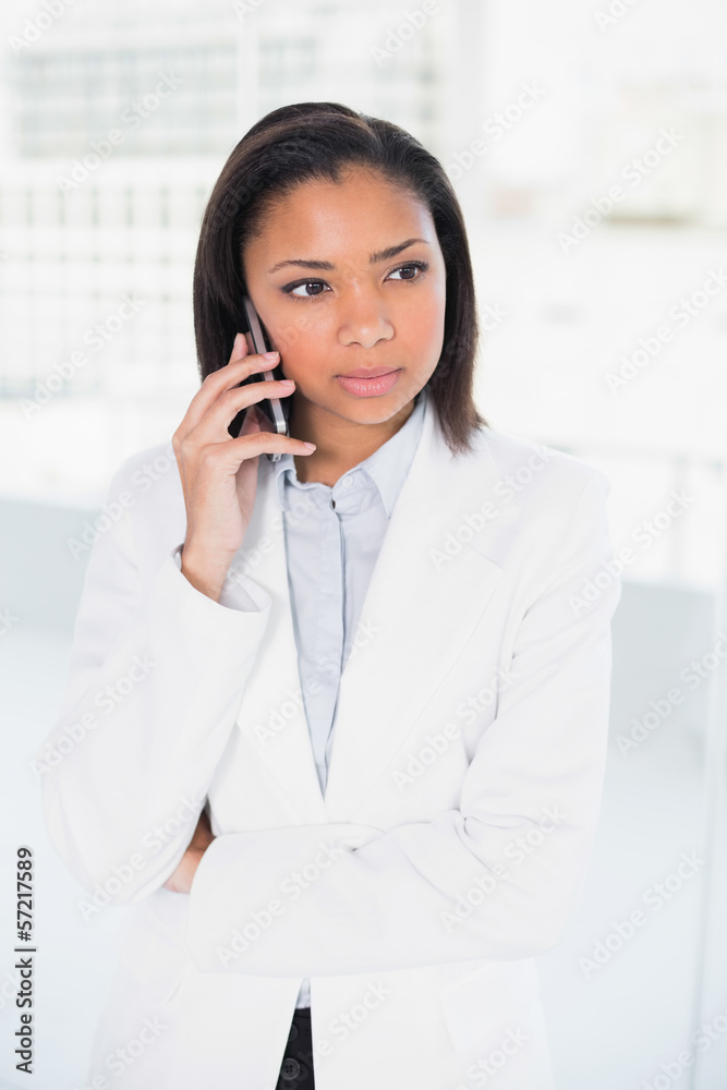 Thoughtful young dark haired businesswoman making a phone call Thoughtful young dark haired businesswoman making a phone call
