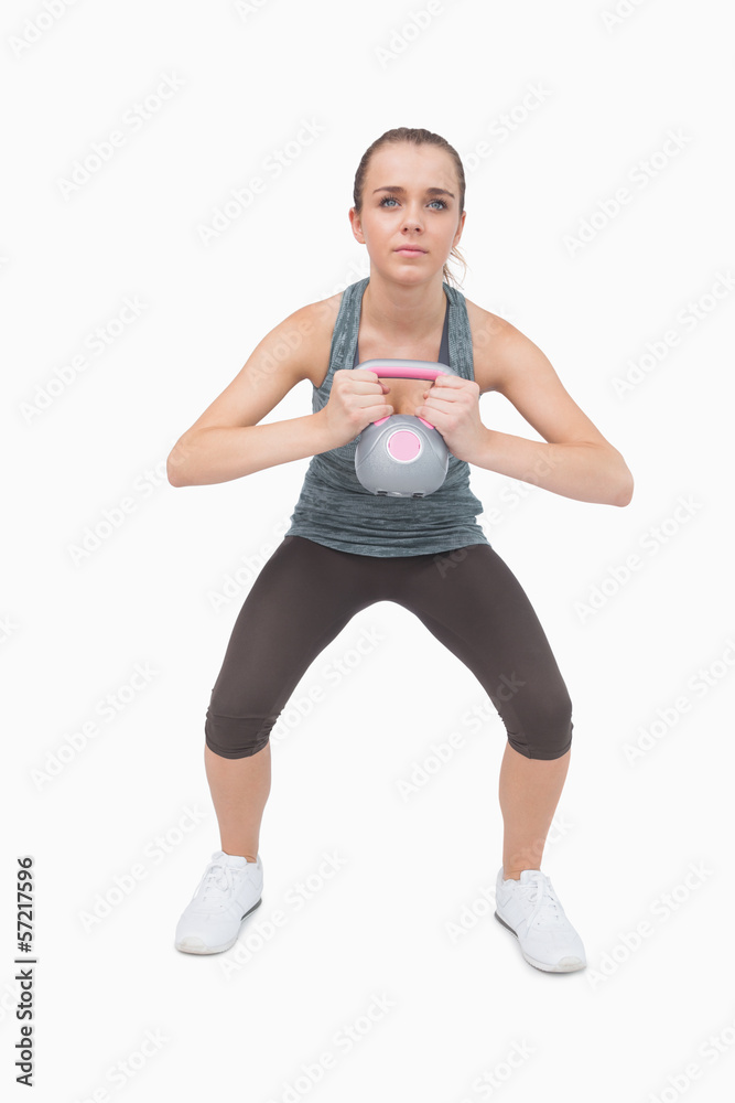 Young woman training her body with a kettle bell Young woman training her body with a kettle bell