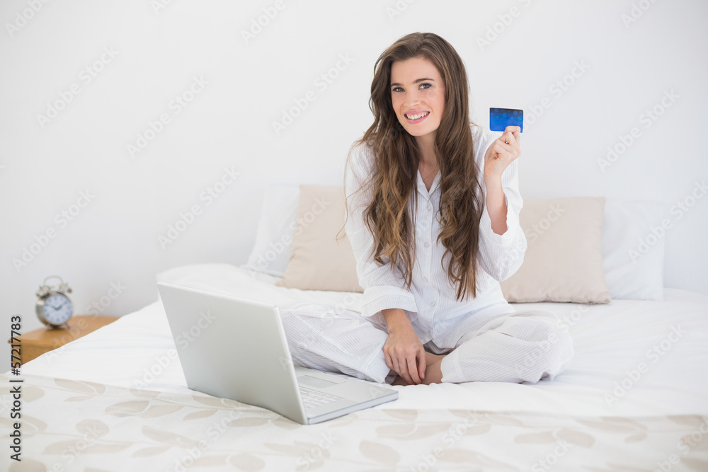 Content casual brown haired woman in white pajamas shopping onli Content casual brown haired woman in white pajamas shopping onli
