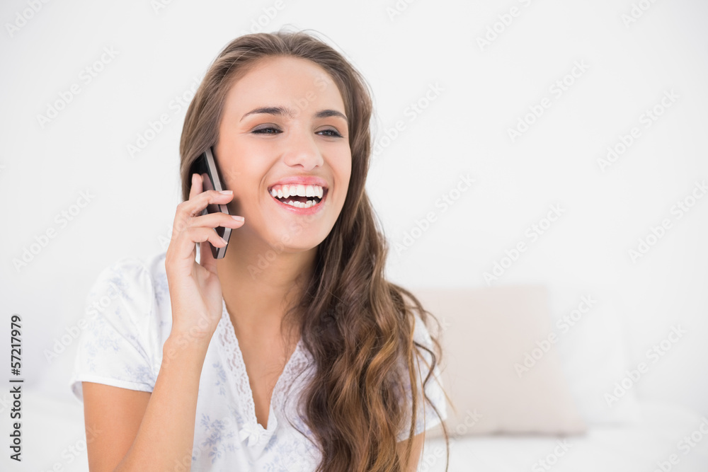 Laughing pretty brunette holding mobile phone Laughing pretty brunette holding mobile phone