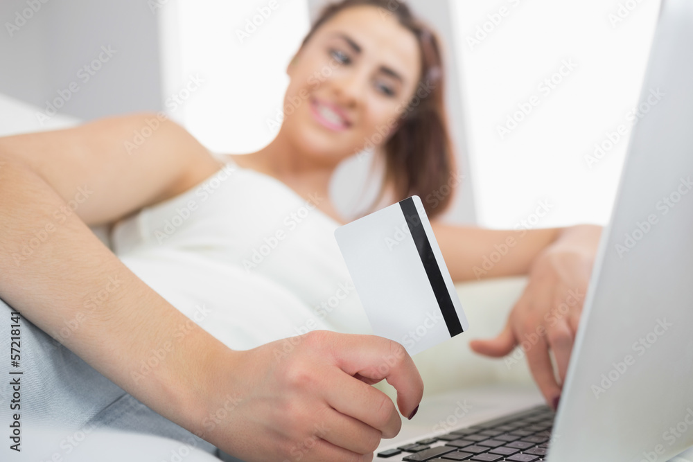 Fototapeta premium Young woman using her notebook for online shopping