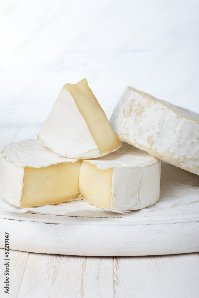 Camembert cheese on cutting board, focus on sliced piece