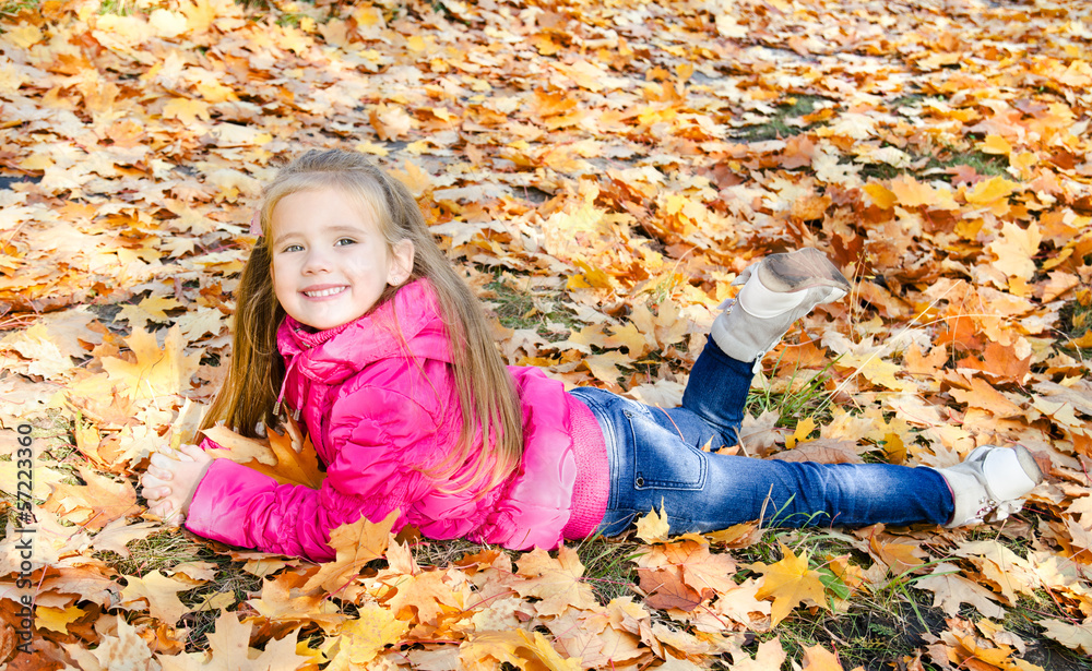 Autumn portrait of cute little girl lying in maple leaves Autumn portrait of cute little girl lying in maple leaves