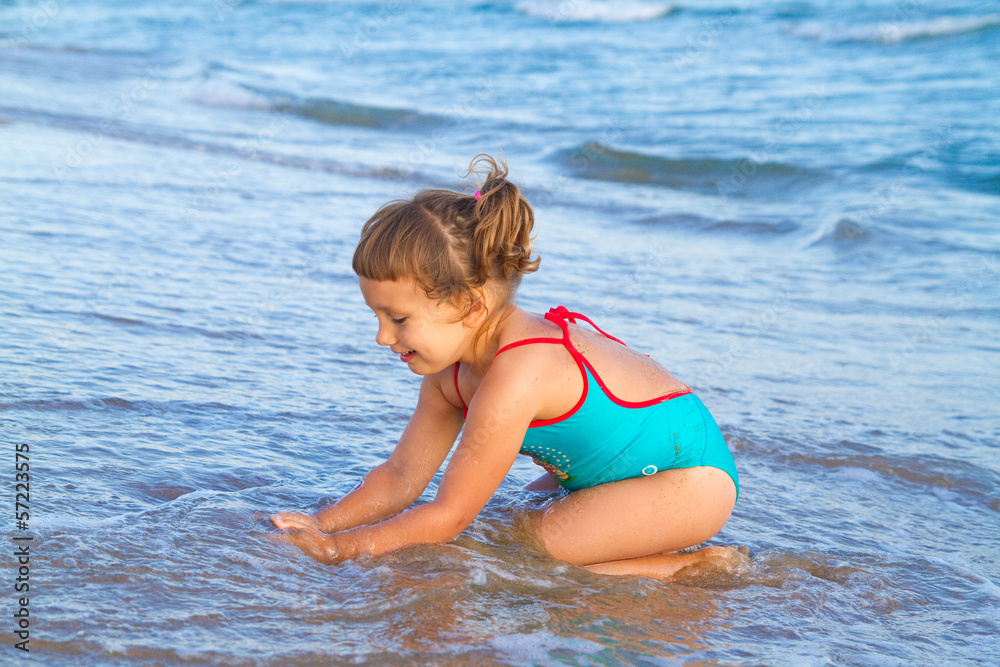girl in a blue bathing suit playing in the water girl in a blue bathing suit playing in the water