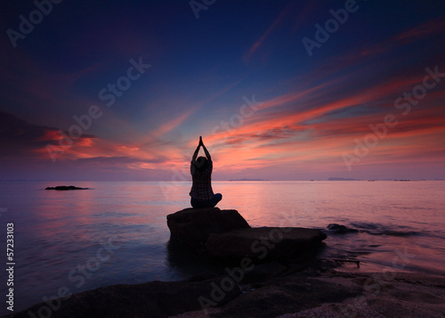 Silhouette yoga girl by the beach sunset