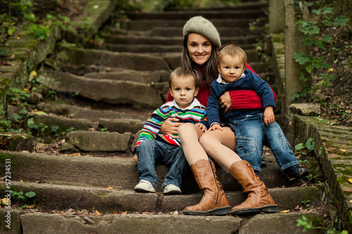 Mother with two boys, sitting on a stairs