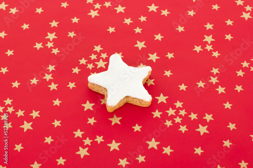 Star shaped cinnamon biscuit on red background