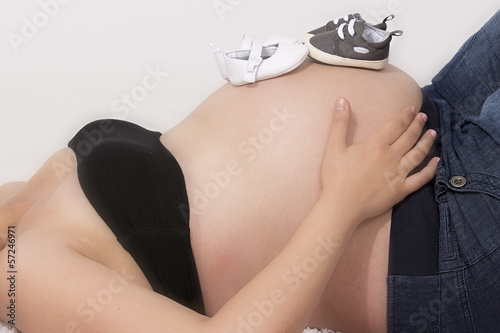Mujer embarazada de gemelos con los zapatitos en la tripa photo