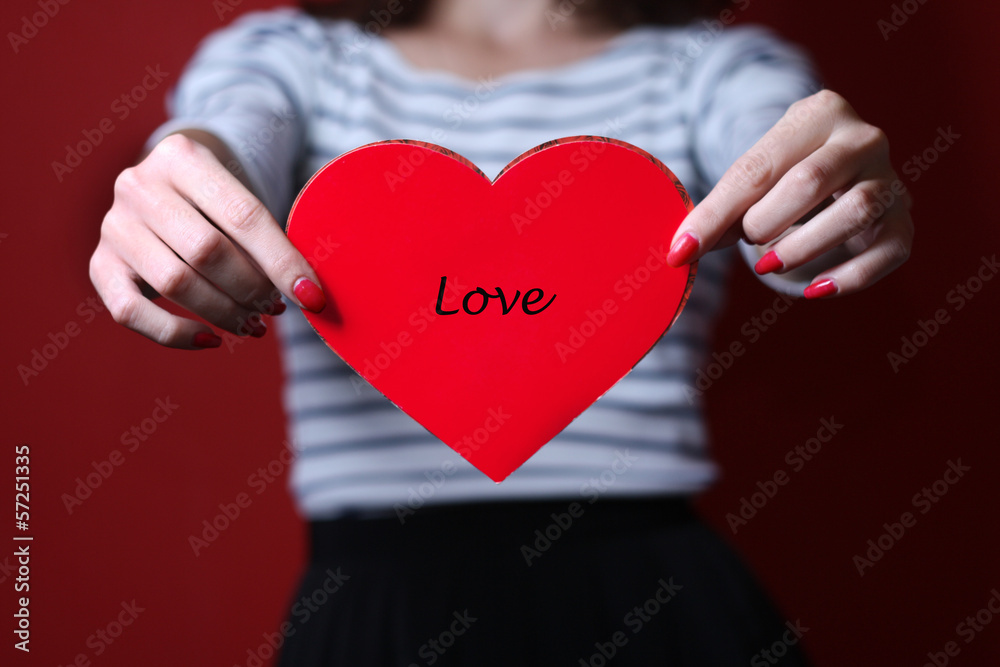 Valentine heart on red background in hands Valentine heart on red background in hands
